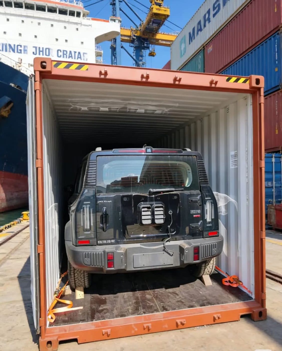 SUV strapped at the wheels inside a 40HQ shipping container